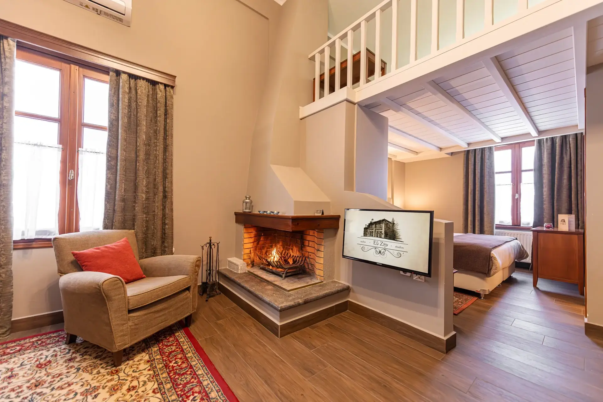 Living area with lit brick fireplace and armchair